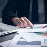 Close up of Businessman analyzing investment charts on the desk.